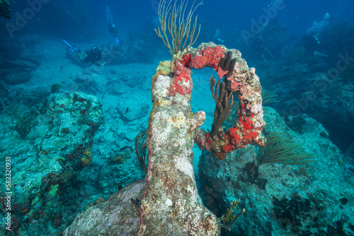 Divers explore the reef and 18th century anchor at the Proselyte dive site off the Dutch Caribbean island of Sint Maarten photo