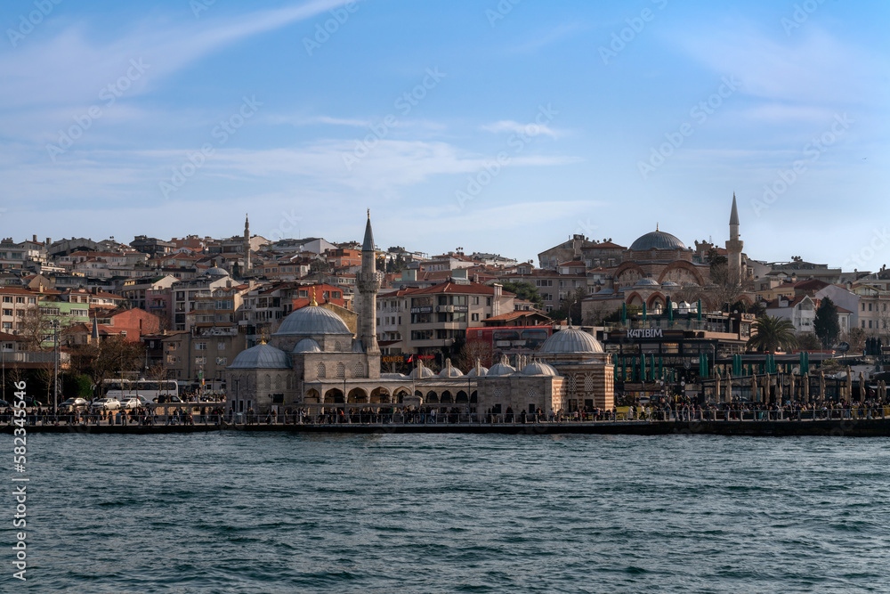 Fototapeta premium Uskyudar district in the Asian part of Istanbul and the Shemsi Ahmed Pasha Mosque from the Bosporus water area on a sunny day, Istanbul, Turkey
