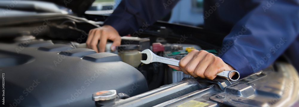 The mechanic works on the engine of the car in the garage, car repair service. The mechanic works on the engine of the car in the garage, car repair service.