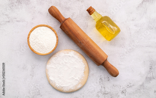 The ingredients for homemade pizza dough with wheat ears ,wheat flour and wheat grains set up on white concrete background.