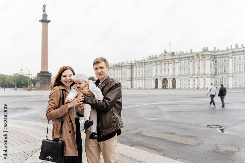 A young happy family with a small child travels around St. Petersburg