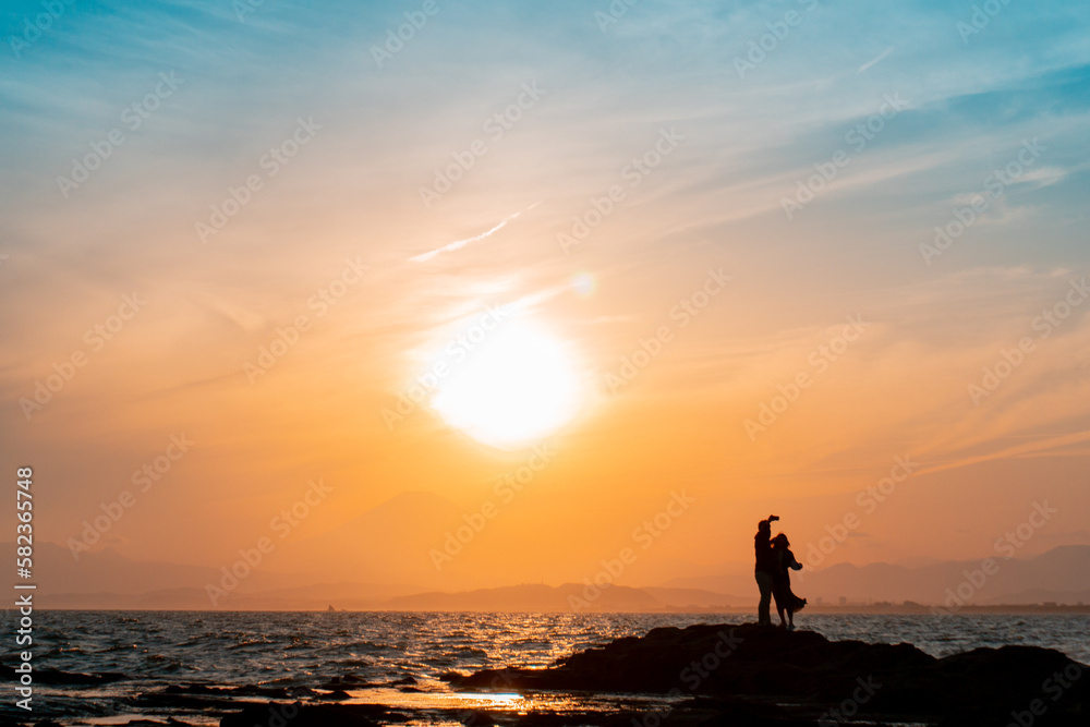 鎌倉の海辺で自撮りを撮るカップル