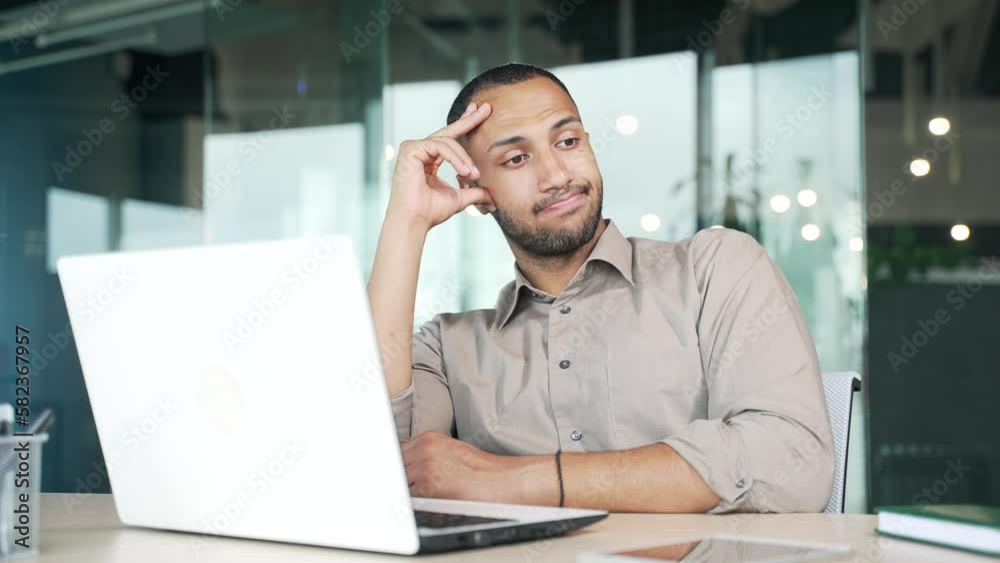 Overworked businessman tired of working with laptop. A young worker is bored at work in the office. The employee cannot concentrate on work. Lazy male procrastinates at the workplace, gets distracted Overworked businessman tired of working with laptop. A young worker is bored at work in the office. The employee cannot concentrate on work. Lazy male procrastinates at the workplace, gets distracted
