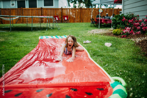 Young girl playing on slip and slide