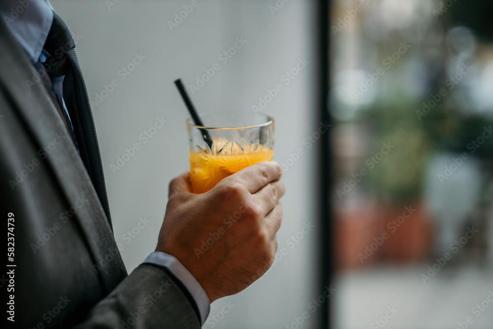 Man hand holding an alcoholic orange beverage. Man hand holding an alcoholic orange beverage.