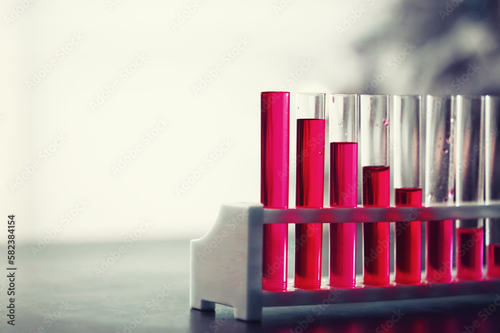 Microscopic examination of blood. Test tubes with red liquid on the laboratory table. Microscopic examination of blood. Test tubes with red liquid on the laboratory table.