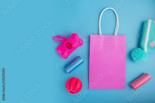 pet shop sale, pet accessories in a shopping bag on a blue background, top view, flat lay, copy space