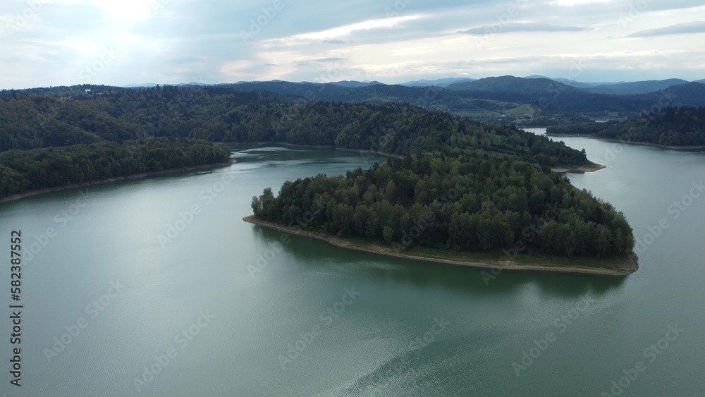 Aerial scenic view of the lake Solina, Jezioro Solińskie, the biggest dam in Poland in autumn at sunset. Recreational area for sail and holidays in the national park of Bieszczady.