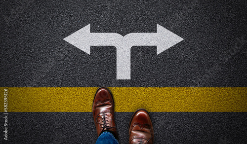 Business man standing with left and right directions arrow on asphalt road. Concept of businessman choice, decision 