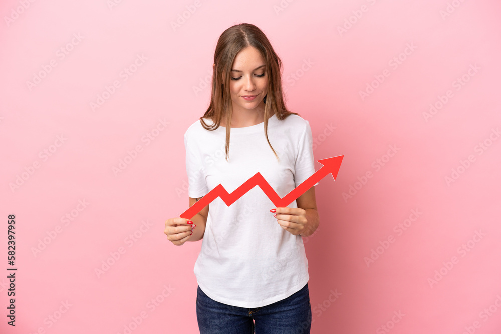 Young Lithuanian woman isolated on pink background holding a catching a rising arrow with happy expression Young Lithuanian woman isolated on pink background holding a catching a rising arrow with happy expression