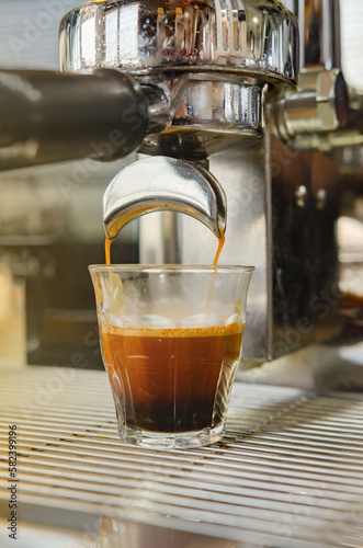 A coffee machine dispenses espresso coffee