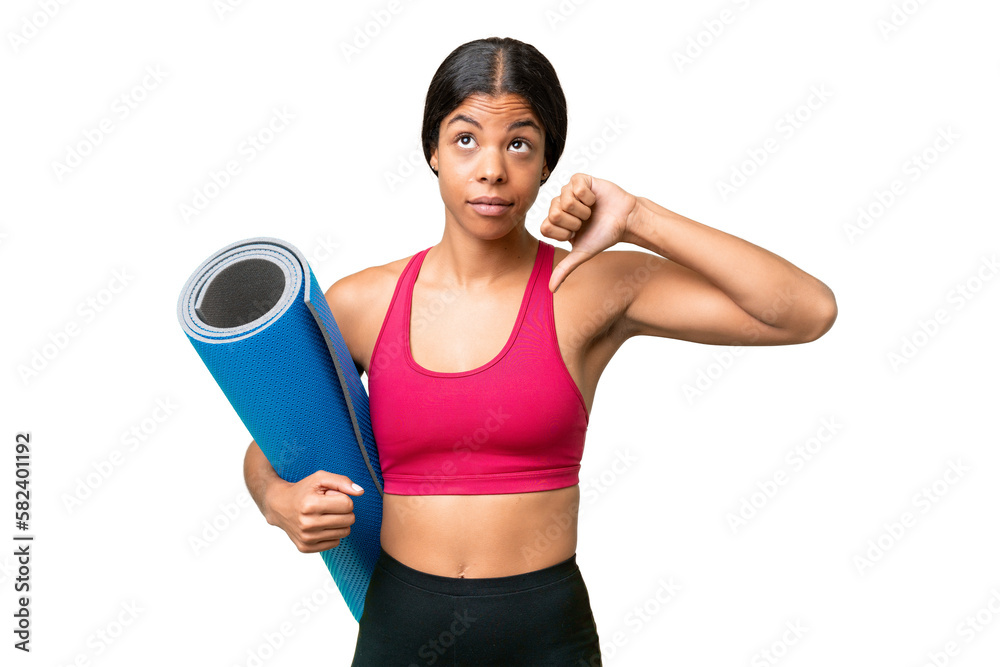 Young sport African American woman going to yoga classes while holding a mat over isolated background showing thumb down with negative expression Young sport African American woman going to yoga classes while holding a mat over isolated background showing thumb down with negative expression