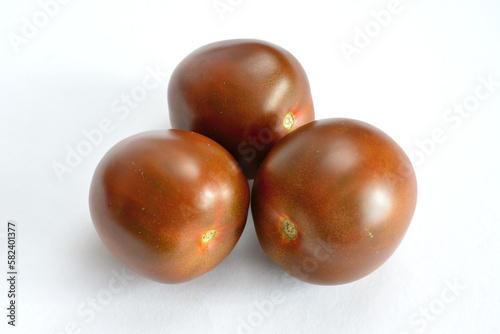 group of black tomatoes isolated on a white background, close-up 