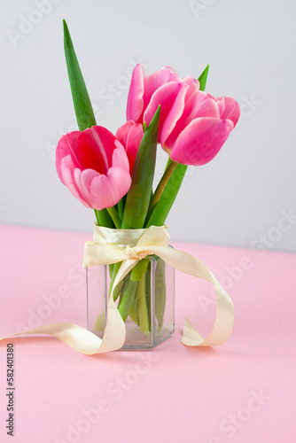 Bouquet of pink tulips in a vase isolated on a light background.