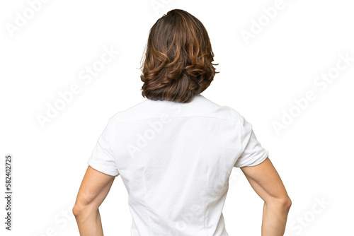 Young caucasian man isolated on green chroma background in back position