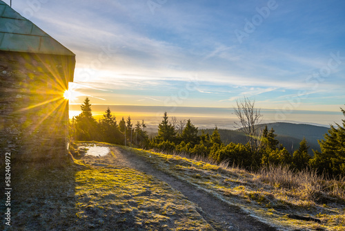 A frosty sunny morning with sun rays shining through a stone tourist shelter at Jeleni studanka in the Hruby Jesenik mountains, Czech Republic photo