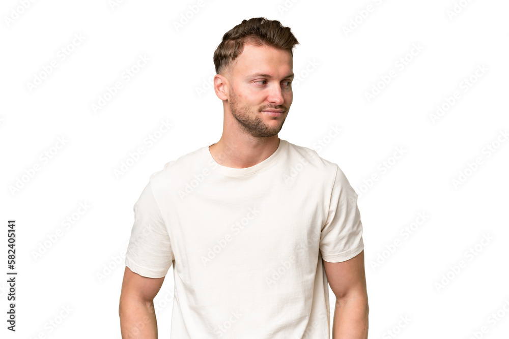 Young blonde caucasian man over isolated background having doubts while looking side Young blonde caucasian man over isolated background having doubts while looking side