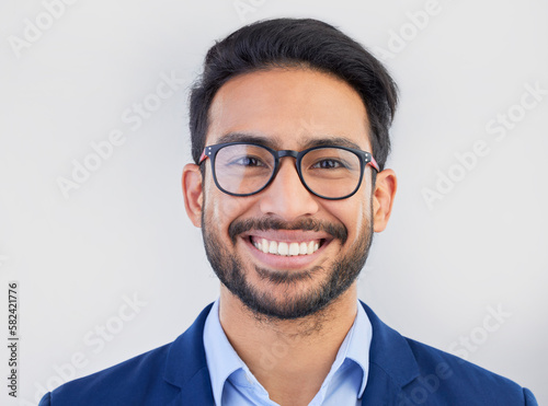 Happy, portrait and excited businessman in studio, smile and confident against a grey background space. Face, happiness and young mexican entrepreneur posing empowered, professional and handsome © Lune/peopleimages.com