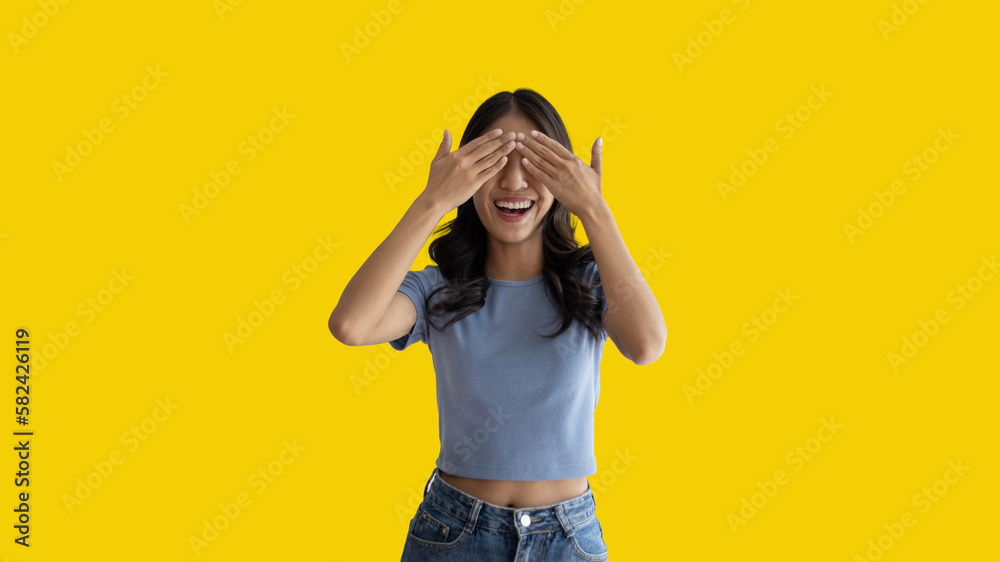 Young woman covering her face and eyes with her hands isolated, Cover your eyes with your hands for fear or prying eyes, Sneak peek, Yellow background. Young woman covering her face and eyes with her hands isolated, Cover your eyes with your hands for fear or prying eyes, Sneak peek, Yellow background.