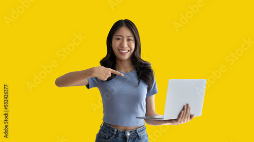 Asian woman in casual clothes holding working laptop in freelance work concept with single laptop can earn money, Invitation to apply or register to receive special privileges and prizes.