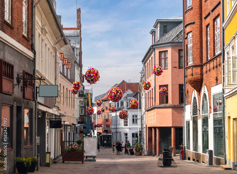 Cityscape of Viborg, Midtjylland, Denmark: traditional danish central high street (Sankt Mathias Gade) decorated with flowers. Different shops and restaurants around.