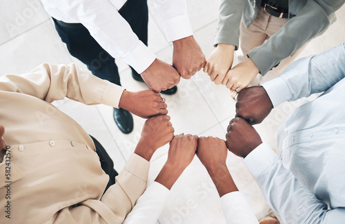 Mission, circle or business people fist bump for partnership or motivation in office meeting together. Diversity, top view or employees with teamwork, strategy or group support for project goal