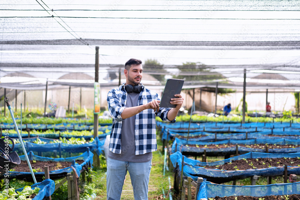 Farmer using digital tablet in the vegetable farm organic smart farm control by science technology Farmer using digital tablet in the vegetable farm organic smart farm control by science technology