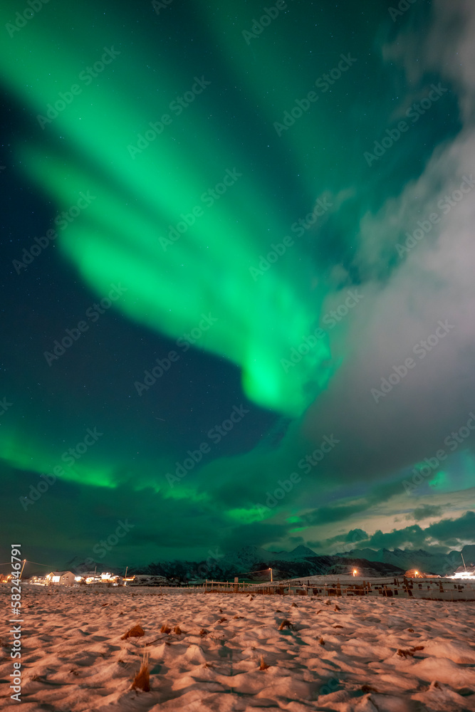 wundervolle Nordlichter über dem Dorf Hillesøy in Troms. begeisterndes Lichtspiel am nächtlichen Himmel, Aurora Borealis über der Insel am Nordatlantik
