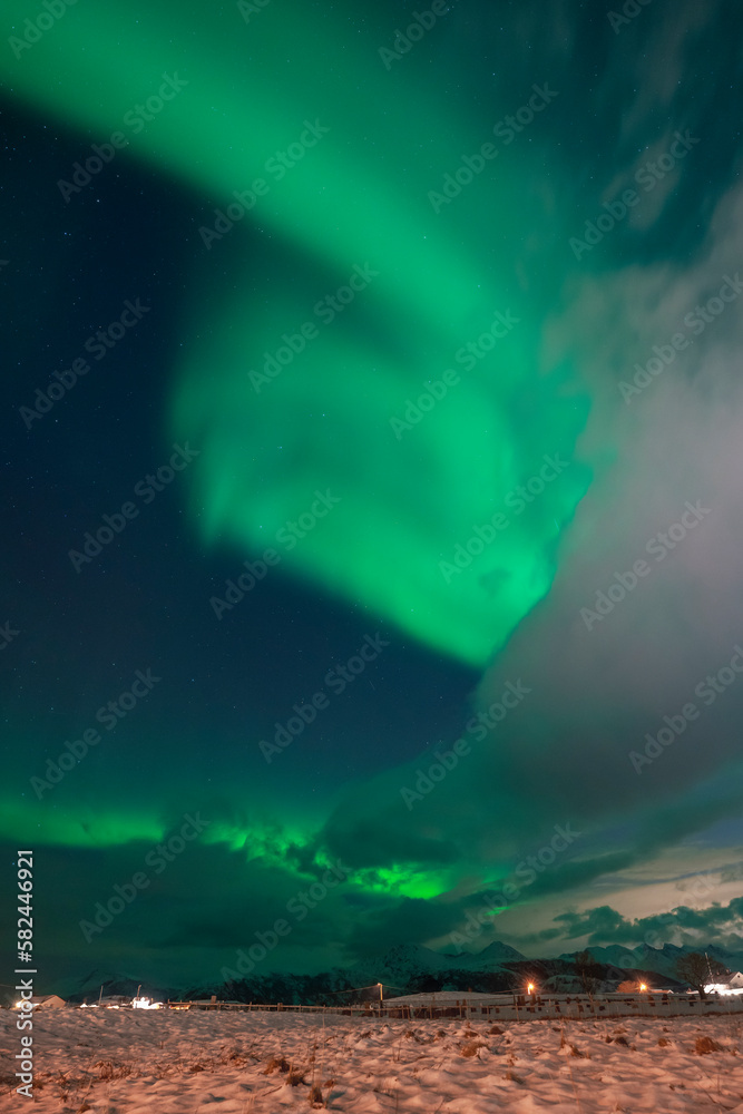 wundervolle Nordlichter über dem Dorf Hillesøy in Troms. begeisterndes Lichtspiel am nächtlichen Himmel, Aurora Borealis über der Insel am Nordatlantik