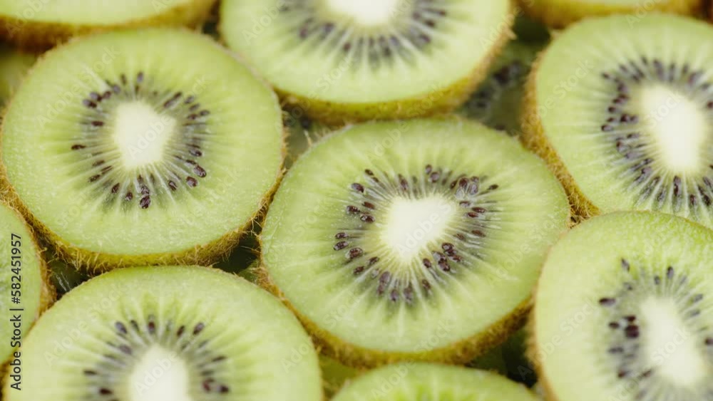 Kiwi Fruit Slices Slowly Turning on a White Background. Freshness and Vitality of Nature in Every Slice. Kiwi Fruit Slices Slowly Turning on a White Background. Freshness and Vitality of Nature in Every Slice.