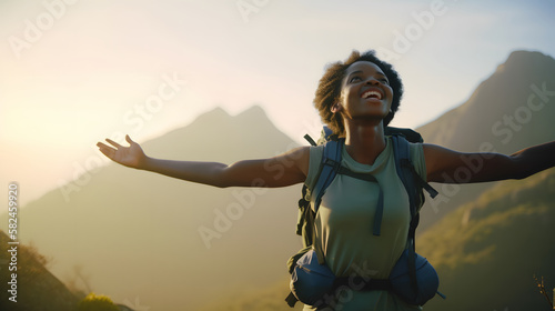 Afro-descendant woman on top of a mountain, with her arms outstretched in triumph