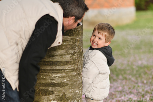 Εκτύπωση καμβά Father and son playing hide and seek in park.