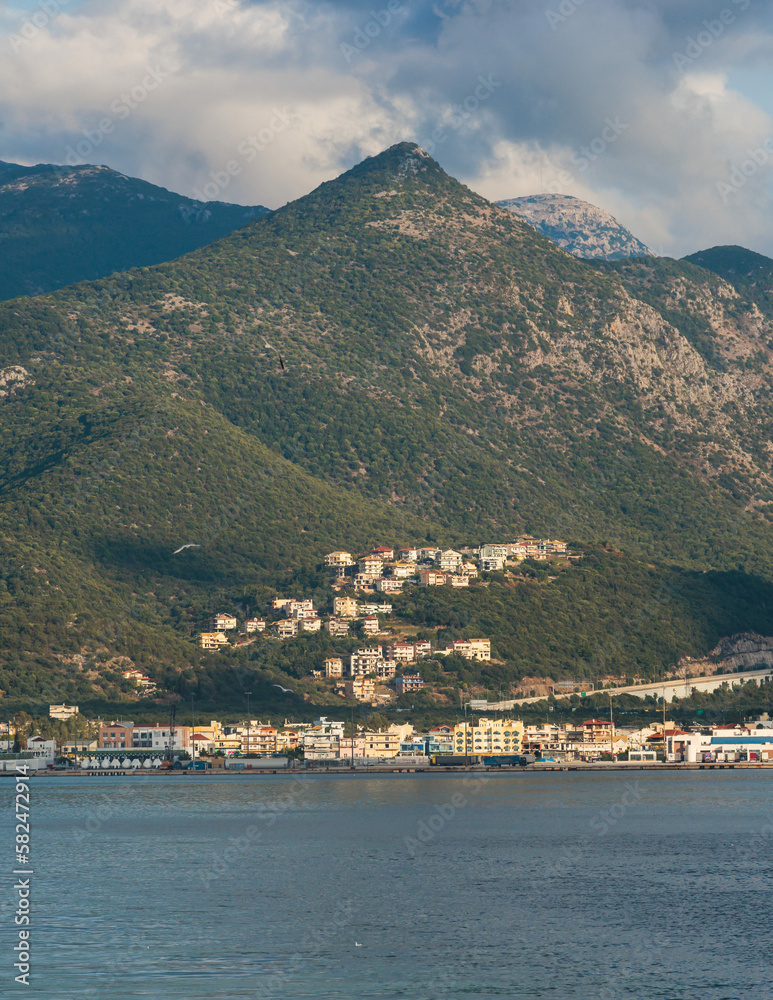 View of Igoumenitsa city harbor, with passenger port, ferry terminal, mountains and Ionian sea, Epirus, Thesprotia, Greece in a summer sunny day with blue sky