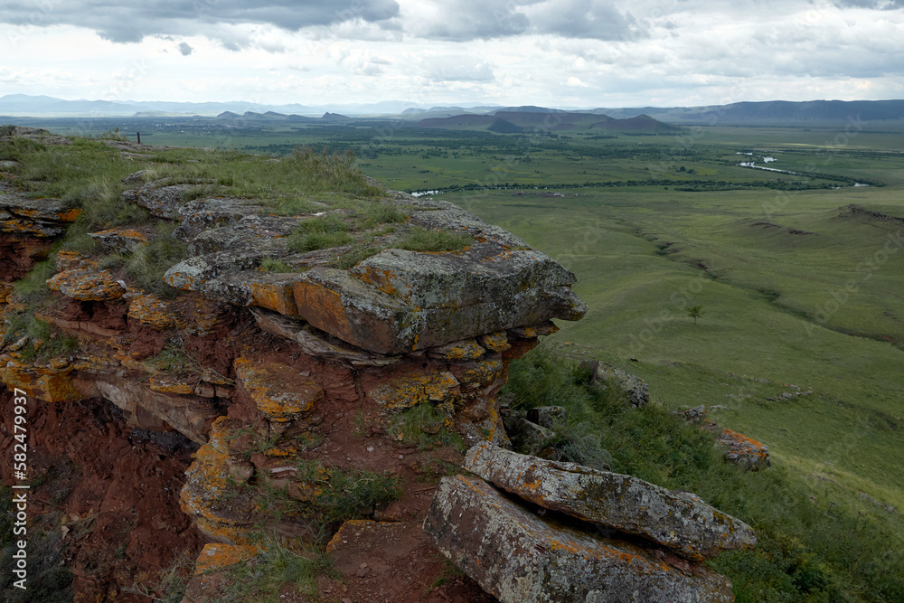 View of the steppe mountains and the lake from the top of the mountain in the chests park in Khakassia. The mountain ridge of Sunduki is a natural and historical monument of nature. 