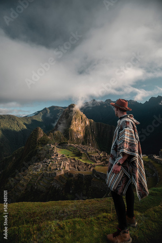 фотографія Vertical shot of a Caucasian hiker overlooking Machu Pichu in Peru