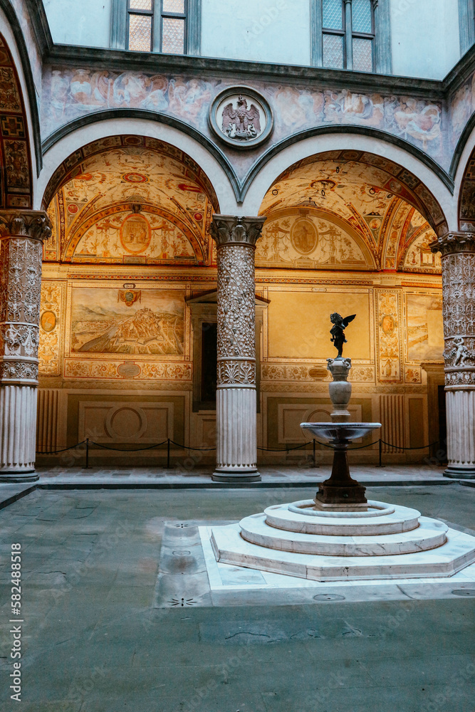 Detail view of renaissance patio in important palace with angel statue in the middle in italian town