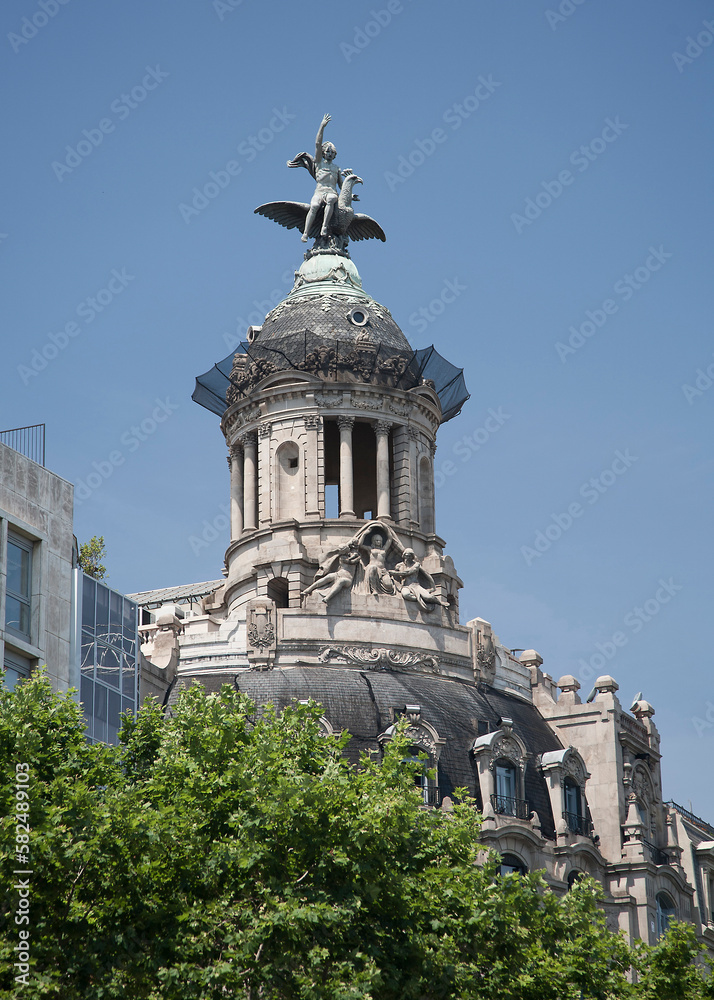 Ornate dome and statue on top of building on Passeig de Gracia Barcelona Spain