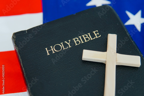 Old Holy Bible with a cross on flag of USA.