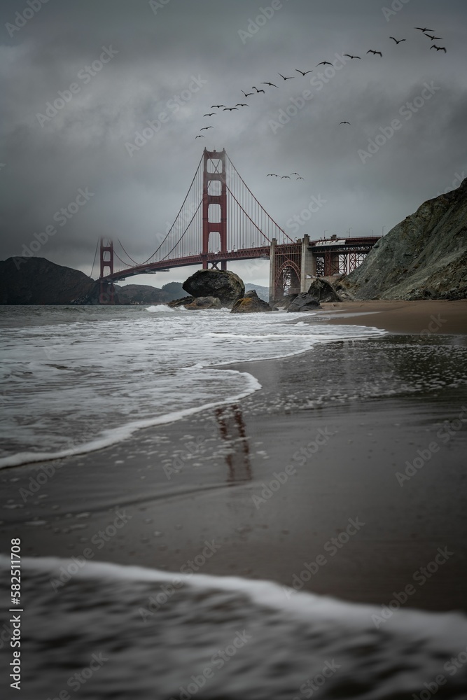 Fototapeta premium Beautiful view of a bridge over ocean water with cloudy sky