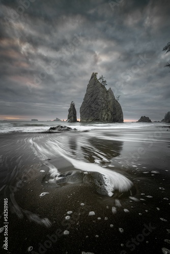 Vertical shot of the cliffs at Rialto Beach on a cloudy day. Olympic National Park, Washington, USA.