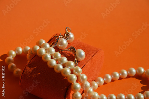 pearl jewelry, beads around the neck, a gold ring with pearls and earrings. women's necklace. background for the design. photo