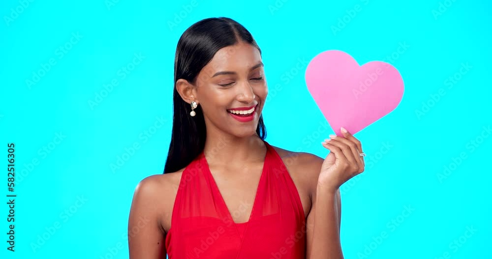 Happy, woman or heart paper sign for Valentines Day, studio care and emoji love icon, symbol or poster. Portrait girl, female beauty or Indian person with romantic support isolated on blue background Happy, woman or heart paper sign for Valentines Day, studio care and emoji love icon, symbol or poster. Portrait girl, female beauty or Indian person with romantic support isolated on blue background