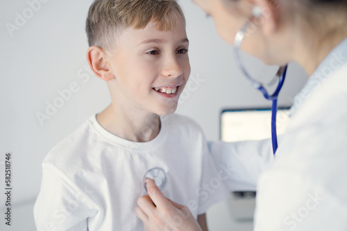 Doctor and happy smiling child boy patient at usual medical inspection in clinic. Medicine  healthcare concepts
