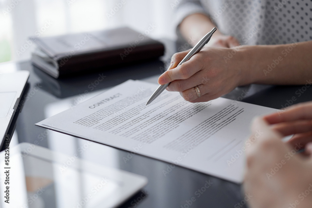Business people signing contract papers while sitting at the glass table in office, closeup. Partners or lawyers working together at meeting. Teamwork, partnership, success concept Business people signing contract papers while sitting at the glass table in office, closeup. Partners or lawyers working together at meeting. Teamwork, partnership, success concept