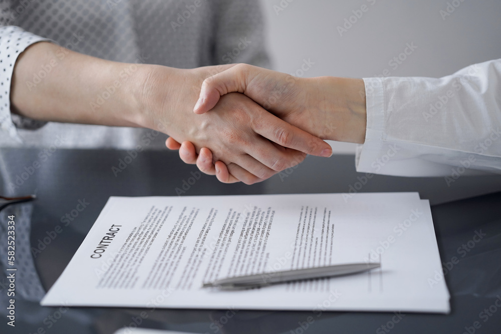 Business people signing contract papers while sitting at the glass table in office, closeup. Partners or lawyers working together at meeting. Teamwork, partnership, success concept Business people signing contract papers while sitting at the glass table in office, closeup. Partners or lawyers working together at meeting. Teamwork, partnership, success concept