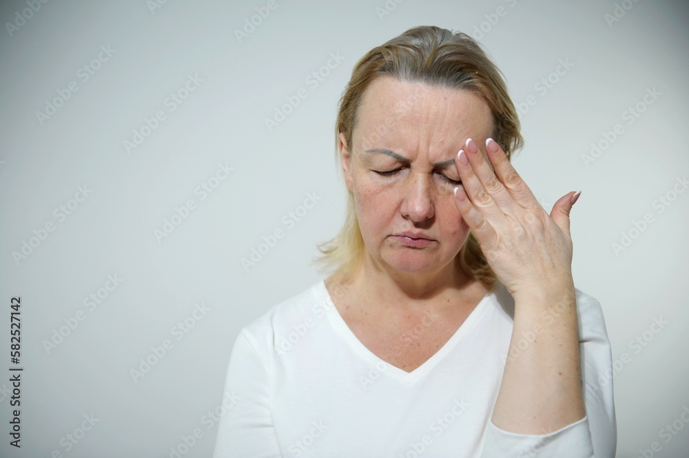 woman put her hand on her head and grimaced headache hard time woman tired she has grown gray hair woman put her hand on her head and grimaced headache hard time woman tired she has grown gray hair
