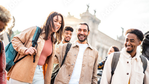 Multi racial happy friends having genuine fun around Barcelona center - Friendship life style concept on young genz people meeting out side together at college campus yard - Bright backlight filter © Mirko Vitali