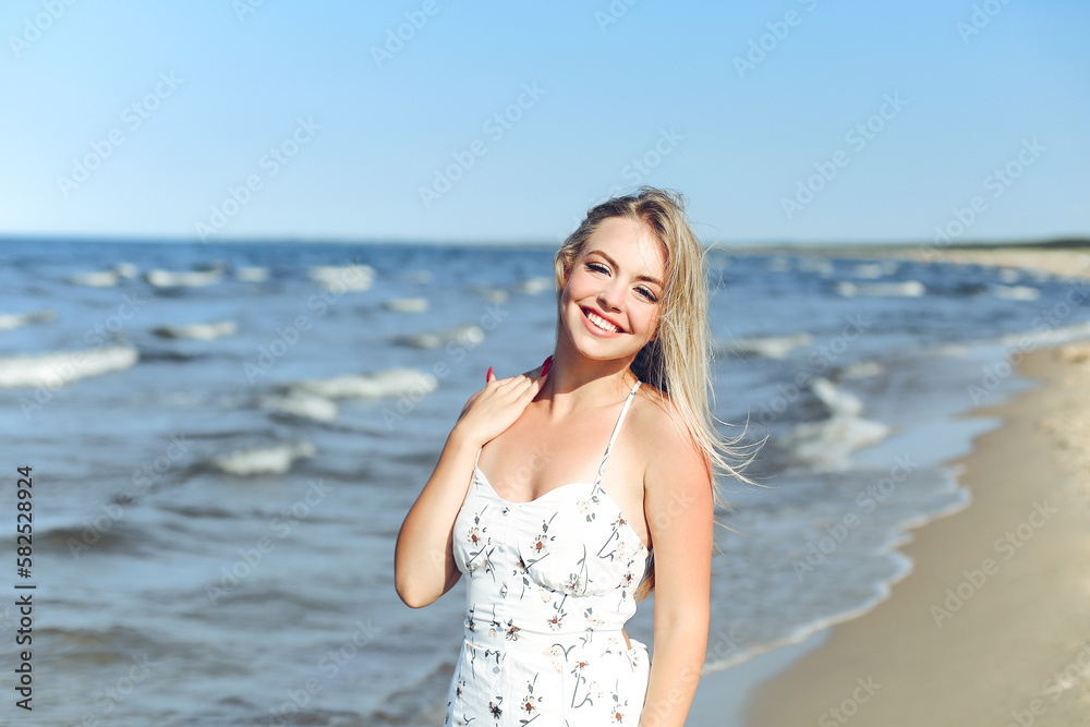 Happy blonde woman in free happiness bliss on ocean beach standing straight and posing