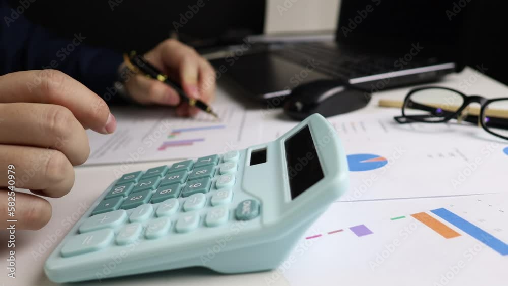Close-up view of male hand using calculator to calculate income for family accounting Close-up view of male hand using calculator to calculate income for family accounting