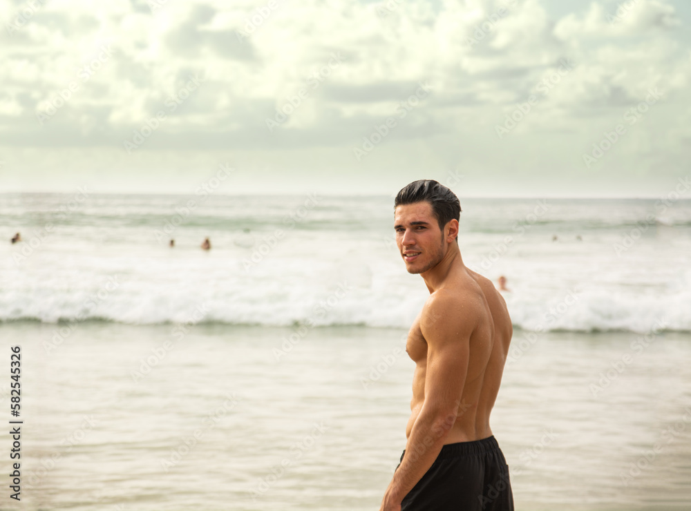 Handsome young man standing on a beach in Phuket Island, Thailand Handsome young man standing on a beach in Phuket Island, Thailand